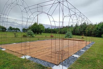 Salle de réception éclairée par des lumières violettes, avec tables hautes décorées de bougies et un espace central dégagé.