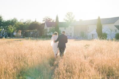Salle de réception éclairée par des lumières violettes, avec tables hautes décorées de bougies et un espace central dégagé.