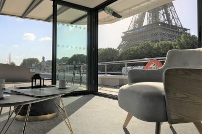 Espace intérieur lumineux avec baies vitrées donnant sur un quai, aménagé avec des fauteuils et une table basse.