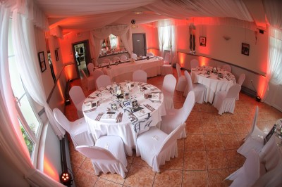 Chambre élégante avec murs bleus, lit double, cheminée, miroir doré, armoire en bois et tapis géométrique.