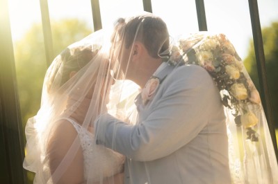 Chambre élégante avec murs bleus, lit double, cheminée, miroir doré, armoire en bois et tapis géométrique.