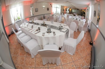 Chambre élégante avec murs bleus, lit double, cheminée, miroir doré, armoire en bois et tapis géométrique.