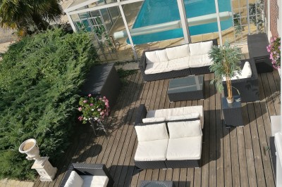 Chambre élégante avec murs bleus, lit double, cheminée, miroir doré, armoire en bois et tapis géométrique.