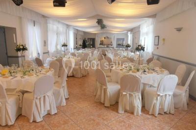 Chambre élégante avec murs bleus, lit double, cheminée, miroir doré, armoire en bois et tapis géométrique.
