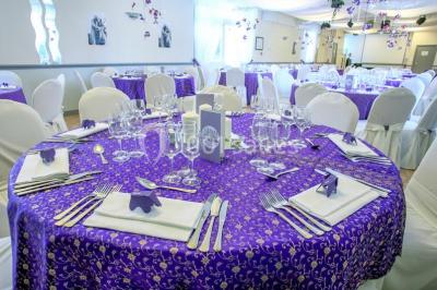 Chambre élégante avec murs bleus, lit double, cheminée, miroir doré, armoire en bois et tapis géométrique.