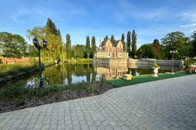 Miniature Location salle Quesmy (Oise) - Château de Quesmy #7 Des personnes pagayant en kayak sur une rivière entourée de végétation sous un ciel nuageux.