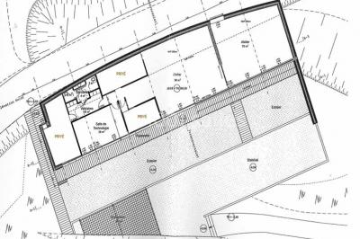 Plan architectural d'un bâtiment avec disposition des pièces, espaces privés et zones extérieures indiquées.