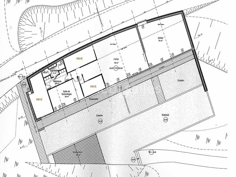Plan architectural d'un bâtiment avec disposition des pièces, espaces privés et zones extérieures indiquées.