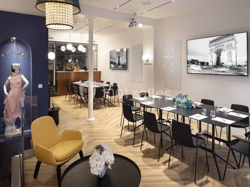 Salle de réunion moderne avec tables noires, chaises, écran affichant l'Arc de Triomphe et décoration élégante.