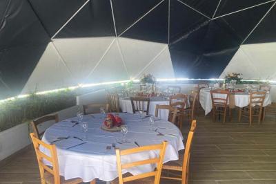 Intérieur d'une tente avec matelas, coffre noir, tapis coloré et vue partielle sur un paysage extérieur.