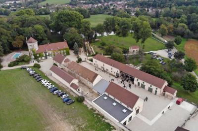 Chambre lumineuse avec un lit double, murs en pierre et peinture bleue, parquet en bois et fenêtre donnant sur la campagne.