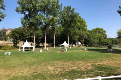 Chambre lumineuse avec un lit double, murs en pierre et peinture bleue, parquet en bois et fenêtre donnant sur la campagne.