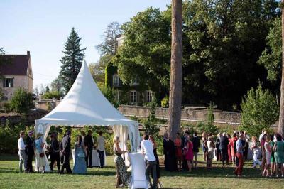 Chambre lumineuse avec un lit double, murs en pierre et peinture bleue, parquet en bois et fenêtre donnant sur la campagne.