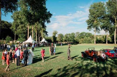 Chambre lumineuse avec un lit double, murs en pierre et peinture bleue, parquet en bois et fenêtre donnant sur la campagne.