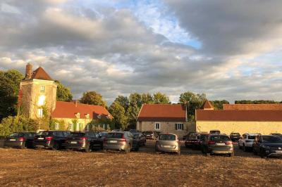 Chambre lumineuse avec un lit double, murs en pierre et peinture bleue, parquet en bois et fenêtre donnant sur la campagne.