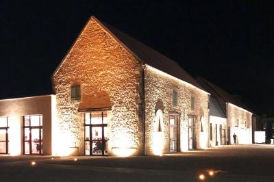 Chambre lumineuse avec un lit double, murs en pierre et peinture bleue, parquet en bois et fenêtre donnant sur la campagne.
