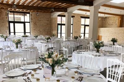 Chambre lumineuse avec un lit double, murs en pierre et peinture bleue, parquet en bois et fenêtre donnant sur la campagne.
