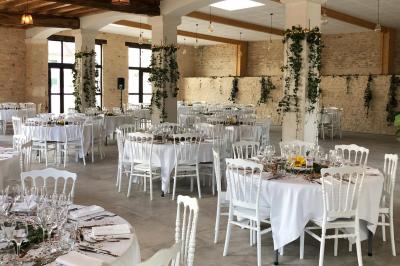 Chambre lumineuse avec un lit double, murs en pierre et peinture bleue, parquet en bois et fenêtre donnant sur la campagne.