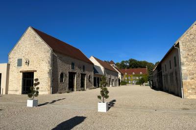 Chambre lumineuse avec un lit double, murs en pierre et peinture bleue, parquet en bois et fenêtre donnant sur la campagne.
