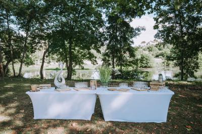 Chambre lumineuse avec un lit double, murs en pierre et peinture bleue, parquet en bois et fenêtre donnant sur la campagne.
