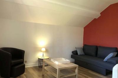 Chambre lumineuse avec un lit double, murs en pierre et peinture bleue, parquet en bois et fenêtre donnant sur la campagne.