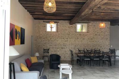 Chambre lumineuse avec un lit double, murs en pierre et peinture bleue, parquet en bois et fenêtre donnant sur la campagne.