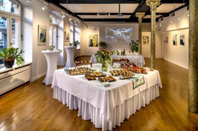 Chambre lumineuse avec un lit simple, des lits superposés en bois, un bureau et une fenêtre donnant sur des toits.