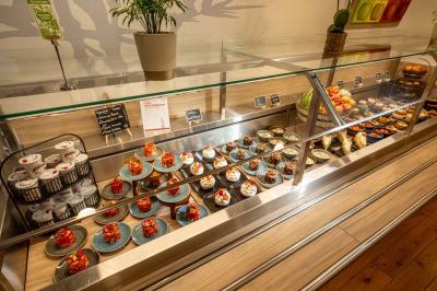 Chambre lumineuse avec un lit simple, des lits superposés en bois, un bureau et une fenêtre donnant sur des toits.