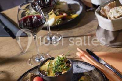 Assiette de repas avec légumes colorés, gratin, pain et verres de vin rouge sur une table en bois.