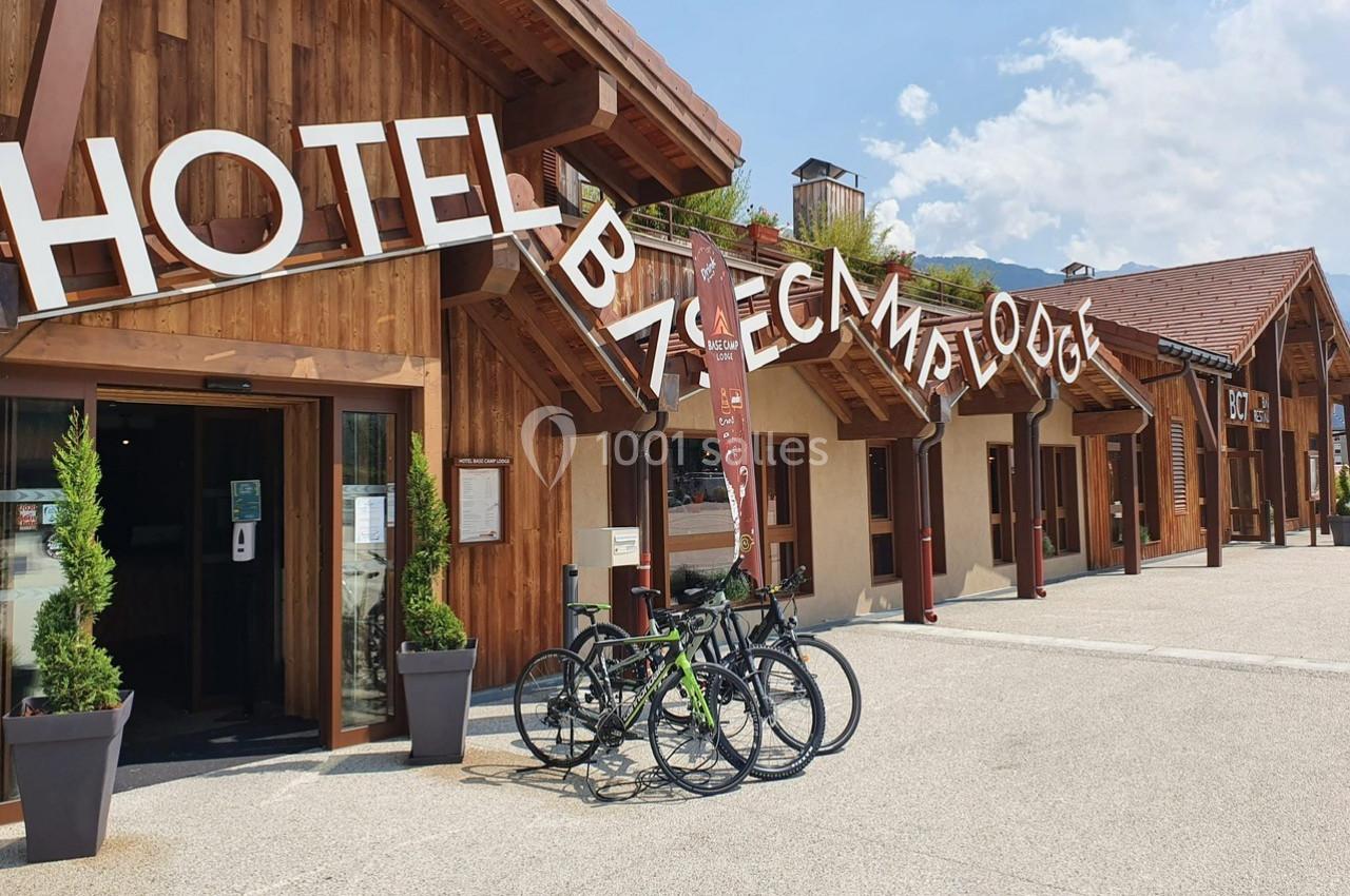 Façade en bois d'un hôtel avec des vélos stationnés devant, sous un ciel dégagé.