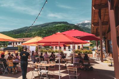 Assiette de repas avec légumes colorés, gratin, pain et verres de vin rouge sur une table en bois.