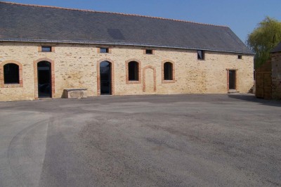 Deux lavabos blancs encastrés dans un plan de travail sombre, avec miroirs et distributeurs de savon muraux rouges.