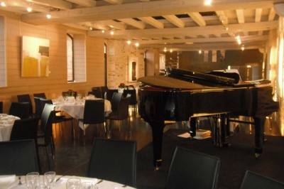 Deux lavabos blancs encastrés dans un plan de travail sombre, avec miroirs et distributeurs de savon muraux rouges.