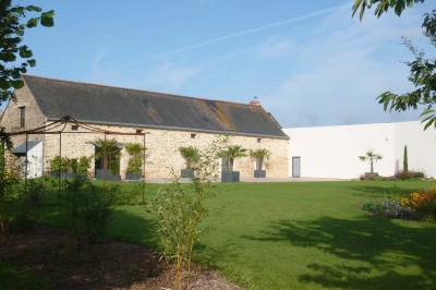 Deux lavabos blancs encastrés dans un plan de travail sombre, avec miroirs et distributeurs de savon muraux rouges.