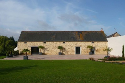 Deux lavabos blancs encastrés dans un plan de travail sombre, avec miroirs et distributeurs de savon muraux rouges.