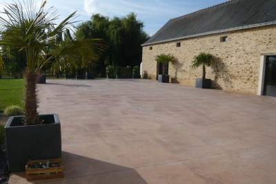 Deux lavabos blancs encastrés dans un plan de travail sombre, avec miroirs et distributeurs de savon muraux rouges.