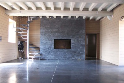 Deux lavabos blancs encastrés dans un plan de travail sombre, avec miroirs et distributeurs de savon muraux rouges.