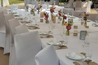 Deux lavabos blancs encastrés dans un plan de travail sombre, avec miroirs et distributeurs de savon muraux rouges.