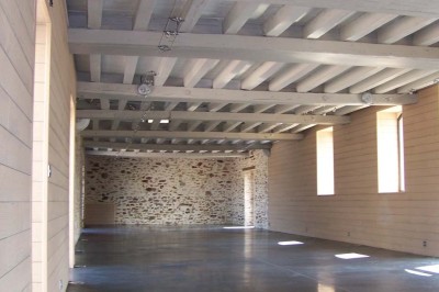 Deux lavabos blancs encastrés dans un plan de travail sombre, avec miroirs et distributeurs de savon muraux rouges.