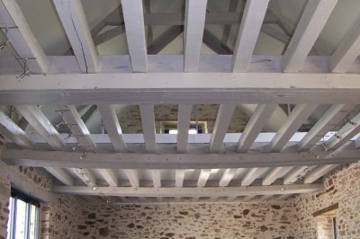 Deux lavabos blancs encastrés dans un plan de travail sombre, avec miroirs et distributeurs de savon muraux rouges.