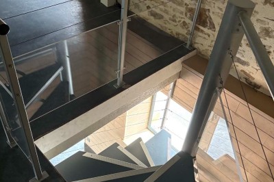 Deux lavabos blancs encastrés dans un plan de travail sombre, avec miroirs et distributeurs de savon muraux rouges.