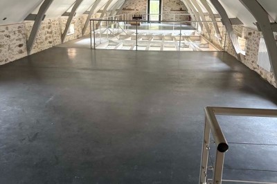 Deux lavabos blancs encastrés dans un plan de travail sombre, avec miroirs et distributeurs de savon muraux rouges.