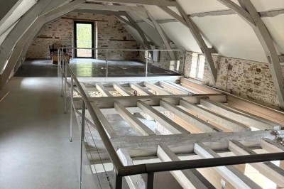 Deux lavabos blancs encastrés dans un plan de travail sombre, avec miroirs et distributeurs de savon muraux rouges.