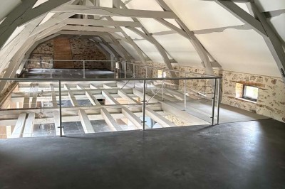 Deux lavabos blancs encastrés dans un plan de travail sombre, avec miroirs et distributeurs de savon muraux rouges.