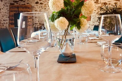 Deux lavabos blancs encastrés dans un plan de travail sombre, avec miroirs et distributeurs de savon muraux rouges.