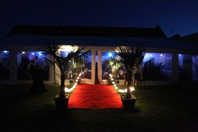 Deux lavabos blancs encastrés dans un plan de travail sombre, avec miroirs et distributeurs de savon muraux rouges.