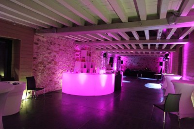 Deux lavabos blancs encastrés dans un plan de travail sombre, avec miroirs et distributeurs de savon muraux rouges.