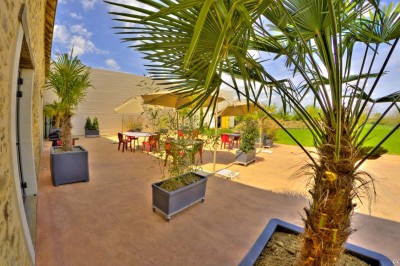 Deux lavabos blancs encastrés dans un plan de travail sombre, avec miroirs et distributeurs de savon muraux rouges.