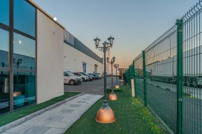 Salle intérieure avec terrain de sport entouré de filets, tables et chaises disposées sur un sol en gazon synthétique.
