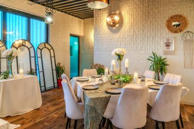 Salle intérieure avec terrain de sport entouré de filets, tables et chaises disposées sur un sol en gazon synthétique.